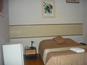 伊基托斯SAFARI HOTEL IQUITOS的一间卧室配有一张床和一张带台灯的桌子