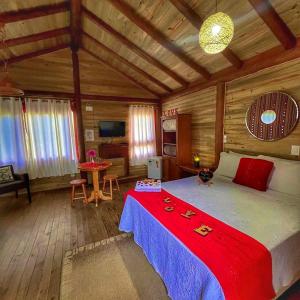 大普拉亚Pousada & Camping Nativos dos Canyons的木制客房内的一间卧室配有一张大床