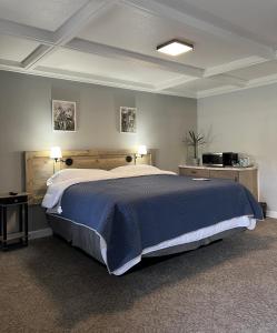 高泉BlueGem Motel的卧室内的一张大床,配有两张桌子和两盏灯