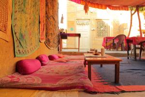 斋沙默尔幻影酒店的客房配有两张带粉红色枕头和桌子的床。