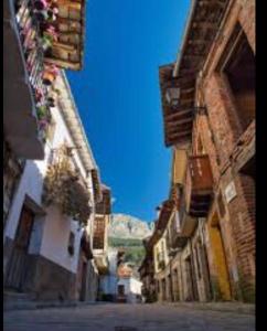 阿维拉Casa Rural Las Pegueras的一条有建筑和蓝天背景的小巷