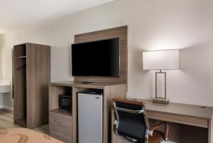 恩波里亚Quality Inn的酒店客房设有电视和带椅子的书桌