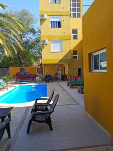 特尔马斯德里奥翁多El Descanso Hotel的一座带两把椅子的游泳池以及一座建筑
