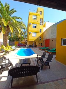 特尔马斯德里奥翁多El Descanso Hotel的一个带椅子的庭院、一个游泳池和一座建筑