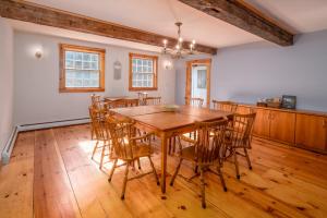East BurkeColonial Home Directly on Kingdom Trails!的一间带木桌和椅子的用餐室