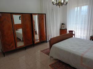 科隆内拉La CASA degli IPPOCASTANI的一间卧室配有一张床和一个带镜子的梳妆台