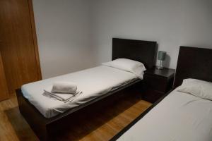 阿林萨尔Apartamento moderno El Bosque en Arinsal的一间小卧室,配有两张带白色床单的床