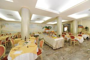 阿巴诺泰尔梅特尔姆帕特里亚酒店的一间设有白色桌椅的餐厅