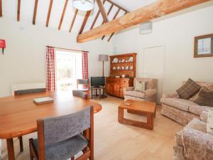 普尔伯勒Byre Cottage 2的客厅配有木桌和沙发