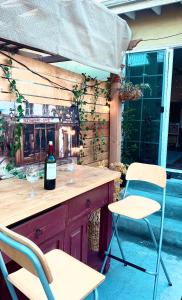 西诺Sweet Tuscan dreams in LA.Private entrance w/patio的酒吧配有两把椅子和一瓶葡萄酒
