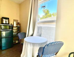 西诺Sweet Tuscan dreams in LA.Private entrance w/patio的窗户间里的一张桌子和两把椅子