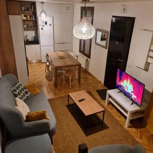 圣但尼SAINT DENIS PARIS STADE de FRANCE DISNEY的客厅配有沙发和带电视的桌子