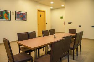 金沙萨AQUA INN Hotel的一间会议室,配有木桌和椅子