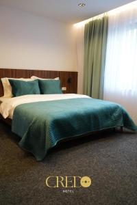 普里兹伦Hotel Credo的一间卧室配有一张带绿毯的大床