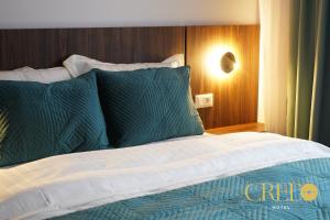 普里兹伦Hotel Credo的一张带绿色和白色床单及枕头的床