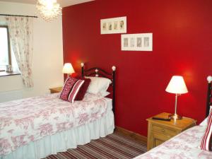 吉斯本Foxhill Barn的一间设有红色墙壁和两张床的卧室
