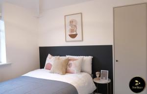 曼彻斯特Bee Stays - Caldecott House的一间卧室配有带粉色和白色枕头的床