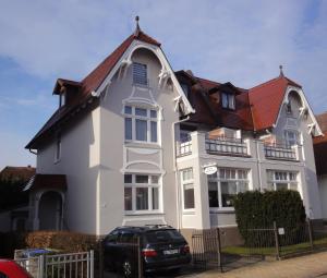 特拉弗明德Ferienwohnungen im Kapitänshaus OSTSEEROSE的白色房子,有红色屋顶