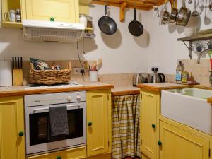 RiggChurch Cottage的厨房配有黄色橱柜和水槽