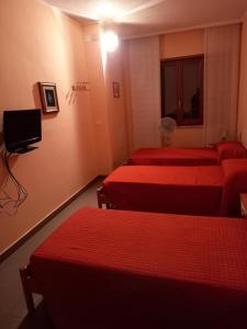 IttiriAffittacamere Su Padru的酒店客房设有三张床和电视。