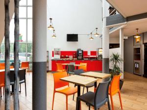 兰斯Hôtel F1 Reims Tinqueux的用餐室配有橙色椅子和桌子
