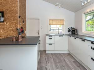 宝可波7 person holiday home in B rkop的厨房配有白色橱柜和黑色台面