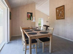 伊斯科博约格6 person holiday home in Eskebjerg的一间带木桌和椅子的用餐室