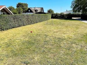 桑德比耶特6 person holiday home in Bjert的草地上一个红色球的院子