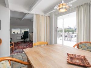 奥特鲁普Holiday home Otterup XXII的一间设有桌子的用餐室,享有客厅的景色