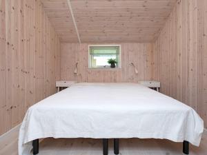 斯泰厄10 person holiday home in Stege的木制客房内的一间白色床卧室
