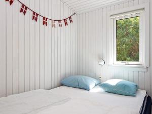 海耶斯Holiday home Hejls LVI的一间卧室配有带两个枕头的床和窗户