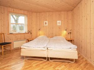 莱斯Holiday home Læsø XX的木墙和窗户的客房内的一张床位