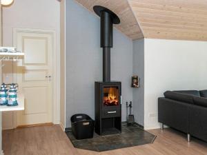 格莱斯堡8 person holiday home in Glesborg的带沙发的客厅内的黑色壁炉