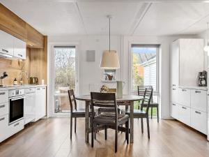 森讷比Apartment Rømø XXXI的厨房配有餐桌和椅子