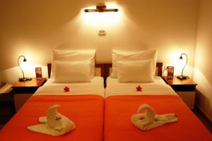 布德瓦Hotel Fineso的一间卧室配有两张床,备有动物毛巾