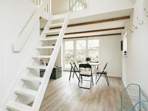 斯卡恩4 star holiday home in Skagen的白色的楼梯,房间配有桌椅