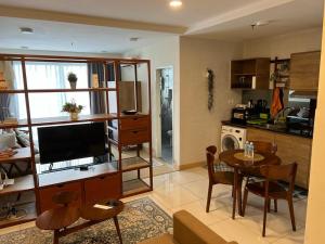 关丹Timur Bay by Dream View Studio的厨房以及带桌子和电视的客厅。