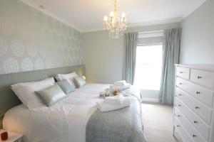 绍斯沃尔德St Marys View, Southwold的卧室配有白色床和吊灯