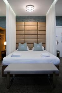 艾尔地平线酒店的卧室配有带蓝色枕头的大型白色床