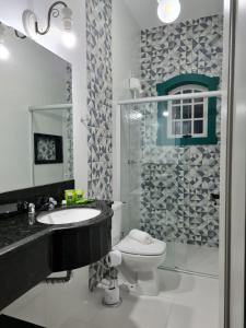 蒂拉登特斯Pousada Candelabro的浴室配有卫生间、盥洗盆和淋浴。