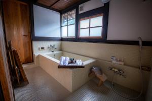 IkunoJapan's oldest remaining company housing的带浴缸、淋浴和卫生间的浴室
