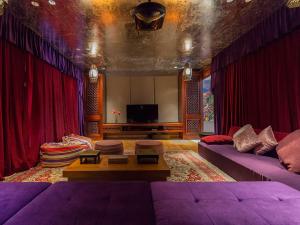 塔巴南Kaba Kaba Estate的客厅配有红色窗帘和紫色沙发