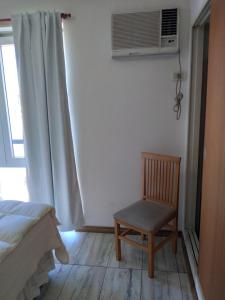罗萨里奥Arcángeles的一间卧室配有椅子和一个带空调的窗户