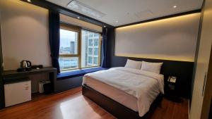 釜山Gold Stone Hotel的一间卧室设有一张大床和一个窗户。