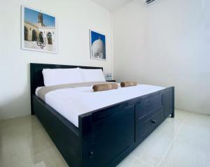 雅加达Ameera Patra Kuningan的一间卧室配有一张大床和黑色橱柜