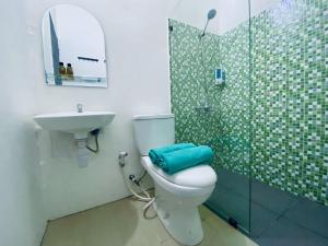 雅加达Ameera Patra Kuningan的浴室配有卫生间、盥洗盆和淋浴。