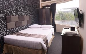 CandiDS Colive Sinabung的酒店客房设有床和窗户。