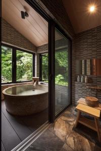 忍野村八海 木花館的带窗户的客房内的大浴缸