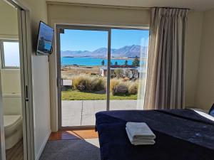 特卡波湖Antair Lakeview Lodge的一间卧室配有一张床,享有海景