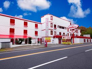 神户图库情趣酒店（仅限成人）的白色建筑前的一条空的街道